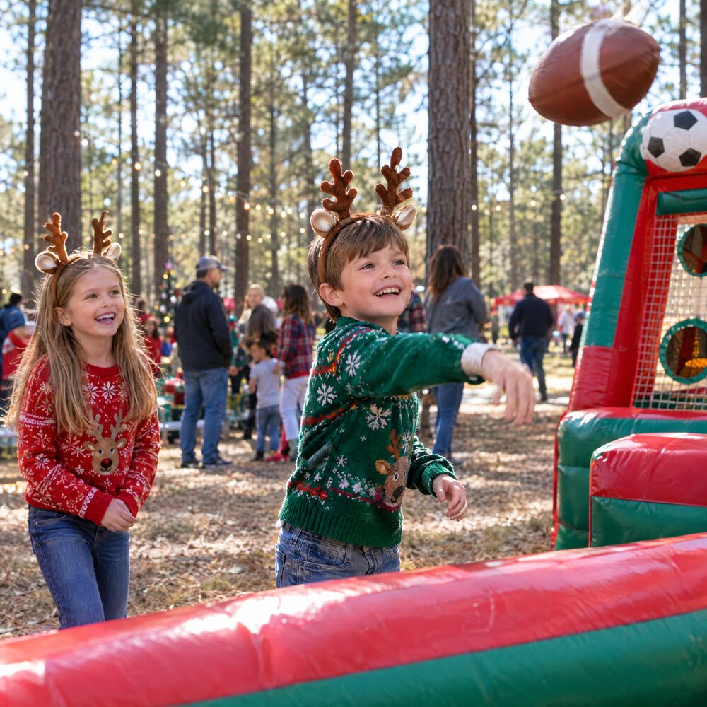 Kids in reindeer antlers playing an inflatable football toss