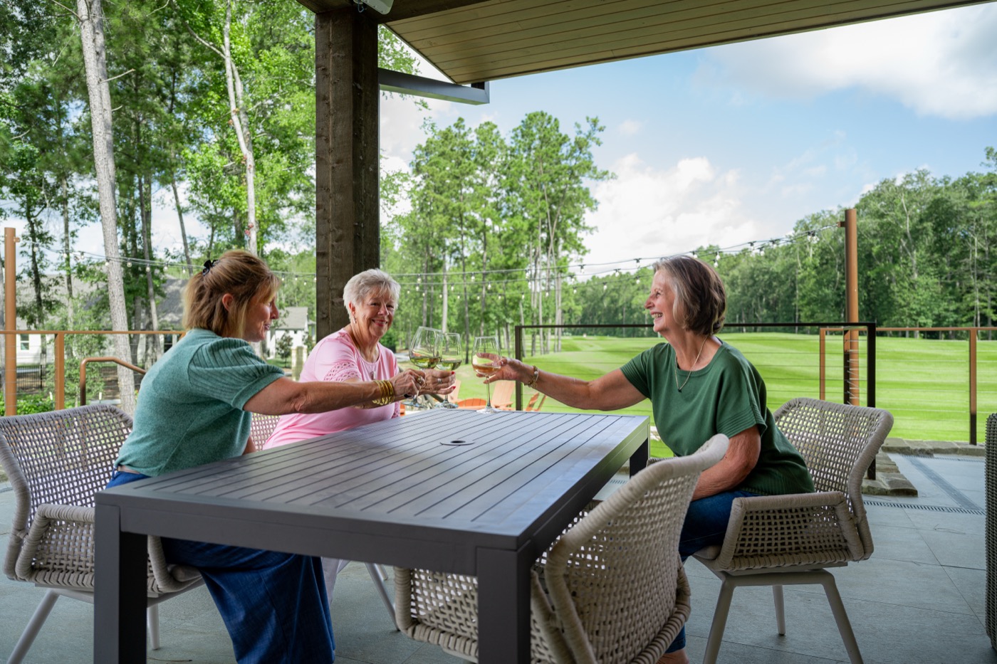 Friends enjoying the patio at The Hideaway overlooking Highland Pines Golf Course